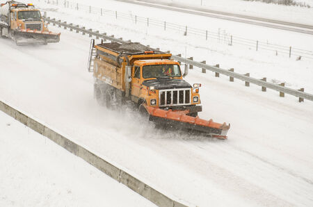 Snow plows clearing the freeway on Interstate 5 during a winter snow and freezing rain stormの写真素材