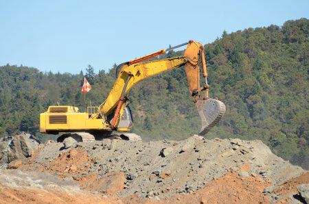 Large exchavator loading articulating dumps at an airport runway extension project