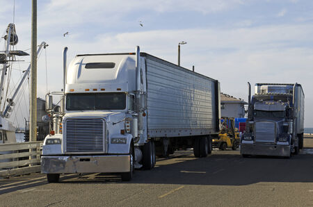 MONTEREY, CA, USA - JUNE 30, 2014: Two trucks waiting on a dock at a fish processor for their load of seafood.のeditorial素材