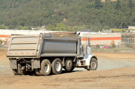 Dump truck at a large construction site removing a hill during an airport runway expansion projectの写真素材