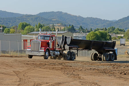 Dump truck at a large construction site removing a hill during an airport runway expansion projectの写真素材