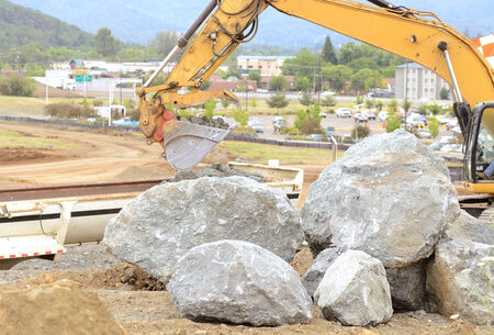 Large rocks needing to be broken up at a construction site to extend an airport runway.の写真素材