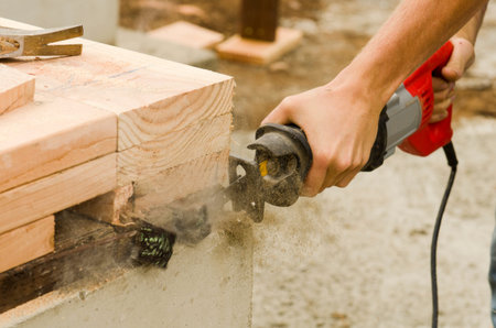 Framing building contractor trimmng up a wall section sill plate for a luxury custom house