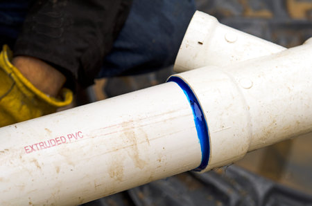 Plumbing building contractor installing plastic drain pipe in the floor section for a luxury custom houseの写真素材