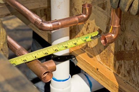 Plumbing contractor works on the copper pipe domestic water system on a luxury custom homeの写真素材