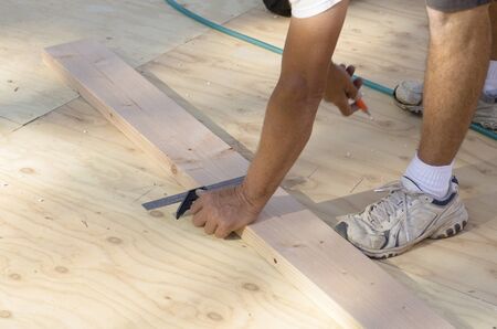Building contractor worker laying out the base plate of a interior bearing wall for the first floor on a new home construction projectの写真素材