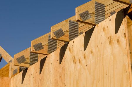 Building contractor carpenter placing new home wood engineered trusses on a residential construction...