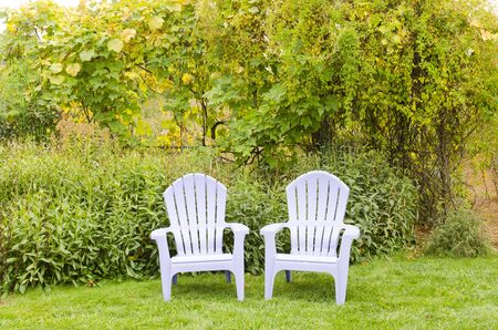 Two chairs sit on a lawn next to a formal garden in the Hood River Valley in Oregonの写真素材