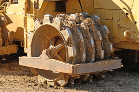Large steel wheeled compactor working the ground at a new commercial housing development