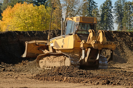 Small bulldozer moving rock and soil in a new commercial housing development