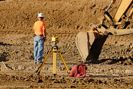 Excavator track hoe diging foundation trenches at a new commercial housing development