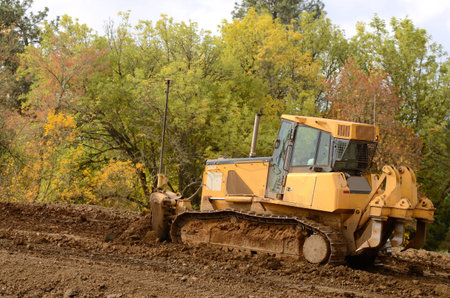 Bulldozer tractor works at moving soil and rock for a new commercial housing development.