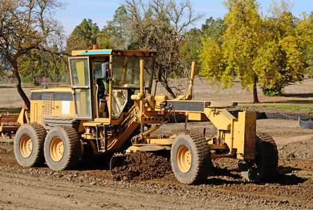 Large road grader working ground at a new commercial housing developmentの写真素材