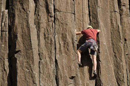 Young man rock climbing at Skinner Butte Climbing Columns. Popular public rock climbing area  in...