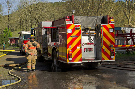 Roseburg OR, USA - March 26, 2014: Fire engine and pump operator engineer on a structure fire of a mobile homeのeditorial素材