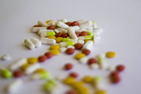 Multicolored medicine pills on a white backgroundの写真素材