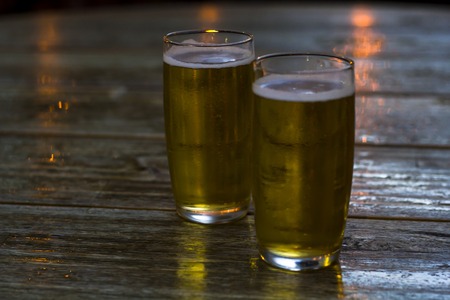 Glasses of beer on wooden tableの写真素材