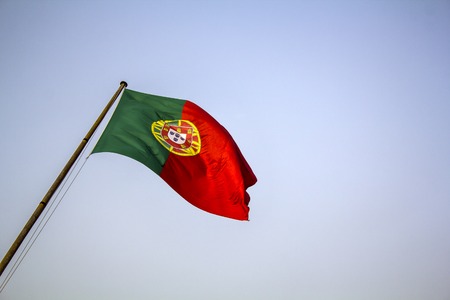 Portuguese flag waving against blue skyの写真素材