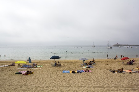SESIMBRA, PORTUGAL - CIRCA SEPTEMBER, 2018: Unidentified people on the beach on hot foggy dayのeditorial素材