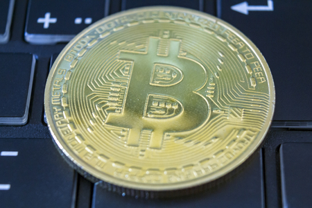 Golden bitcoin on keyboard. Digital currency conceptの写真素材