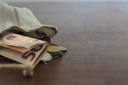 Money spilling from a bagの写真素材