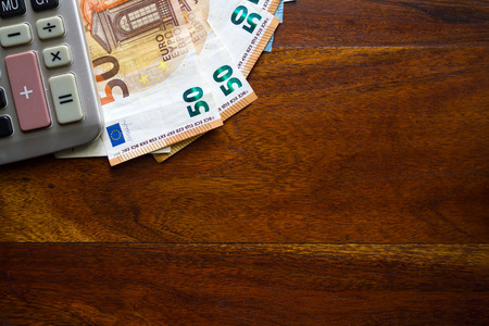 Money and calculator on wooden table. Top viewの写真素材