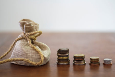 Money bag and Coin stacks on a wooden table
