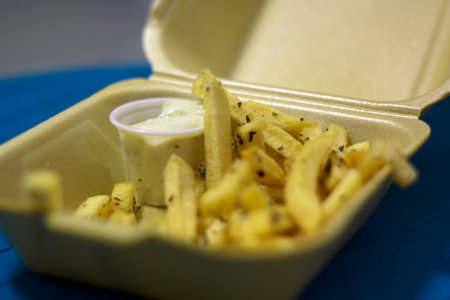 French fries with garlic sauce on Disposable container