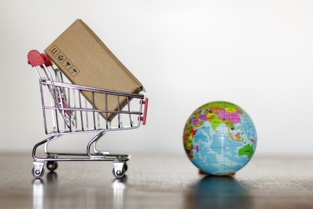 Trolley with carton and earth globe. Worldwide shopping and delivery business conceptの写真素材
