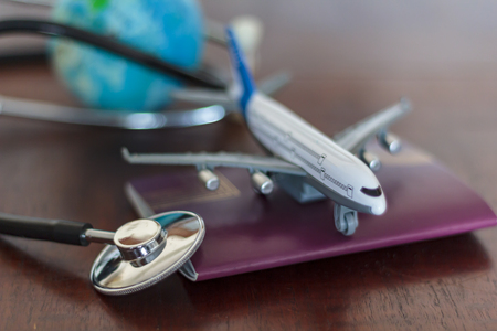 Stethoscope , passport document, airplane and globe. Global Healthcare and travel insurance conceptの写真素材