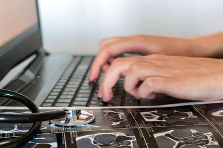 Doctor writes medical report on the computerの写真素材