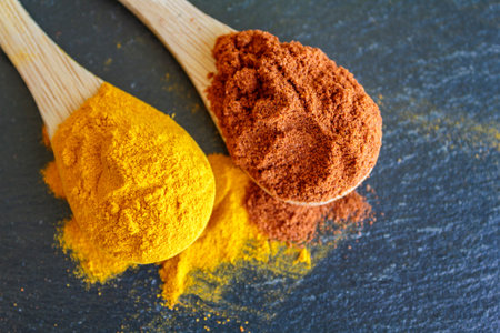 Top view of spoons with cayenne pepper and turmeric powder