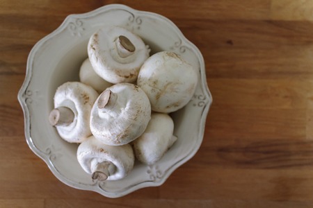 Top view of champignon mushrooms on rustic bowlの写真素材