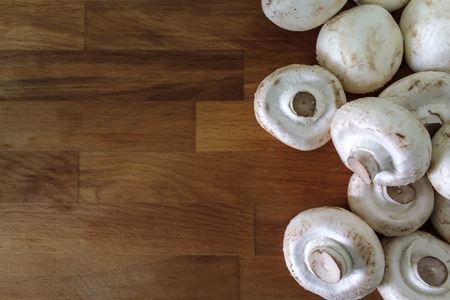 Top view of white mushrooms on wooden table with copy spaceの写真素材