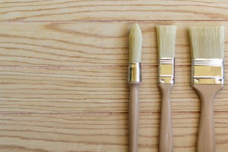 Top view of paint brushes on wooden tableの写真素材