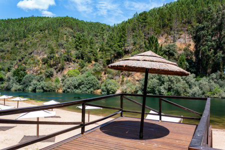 Straw umbrella on river beachの写真素材