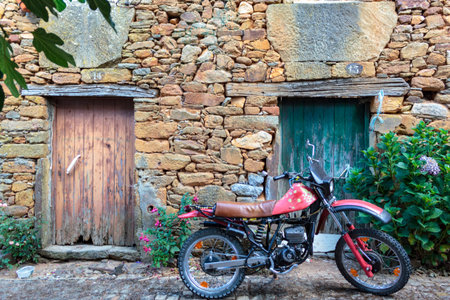 Vintage motorcycle parked in front of old house