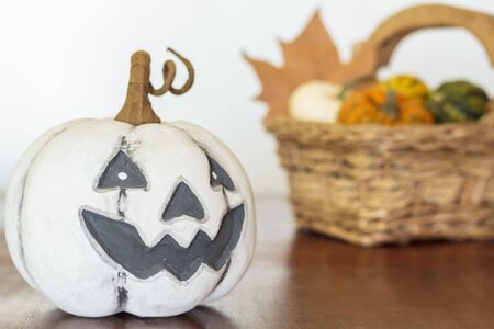 Halloween pumpkin on wooden table and basket with pumpkins on the backgroundの写真素材