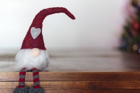 Christmas gnome sitting on wooden table with copy spaceの写真素材