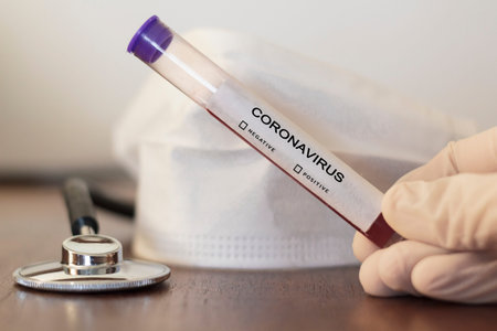 Face mask, stethoscope and hand with gloves holding blood test for Coronavirus (2019-nCoV)