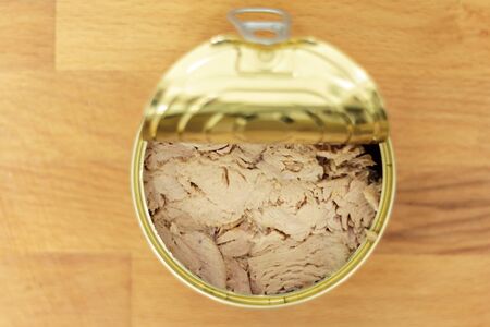 Top view of can of tuna on wooden boardの写真素材