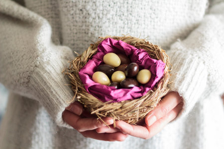 Woman hands holding a nest with sweet Easter almonds