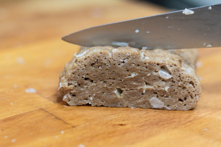 Slicing homemade seitan on wooden board