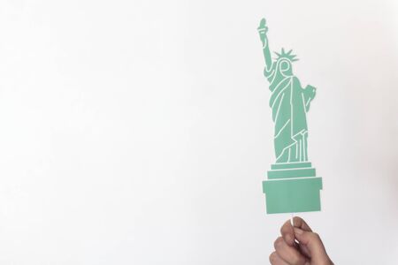 Woman hand holding statue of Liberty props with copy space. USA holiday, 4 of July, celebration concept.の写真素材