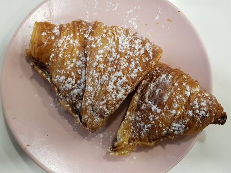 Top view of french croissant with chocolate filling on plateの写真素材