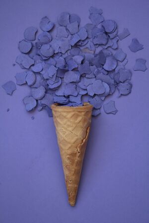Top view of ice cream cone with purple confetti on purple backgroundの写真素材