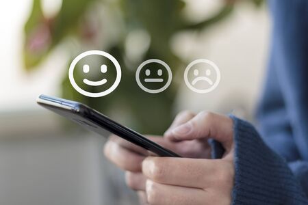 Woman using smartphone for service rating and customer satisfactionの写真素材