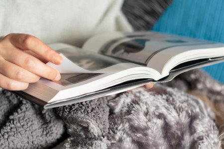 Woman with warm blanket reading a book