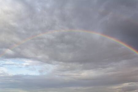 Full rainbow and cloudsの写真素材