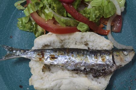Top view roasted sardine on bread and salad with lettuce and roasted red pepper. Portugal typical cuisineの写真素材